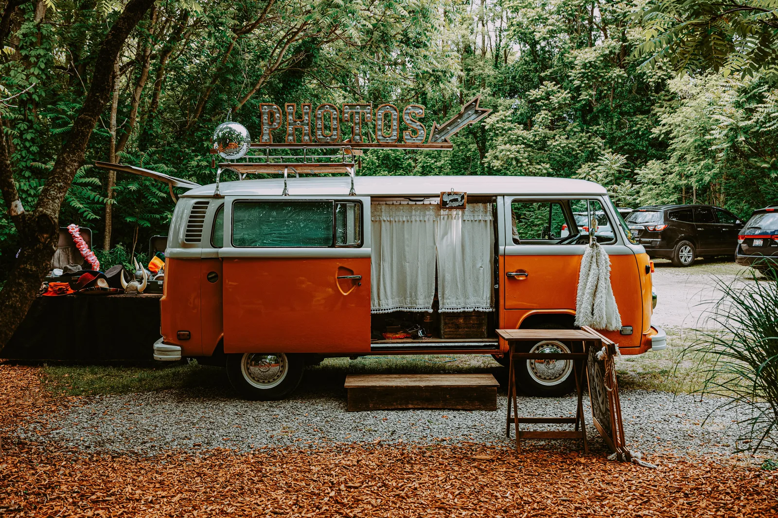 Charming vintage Volkswagen van photobooth in a lush outdoor setting, perfect for events. Photo Booth Rental Tax Deductions: Cost Categories